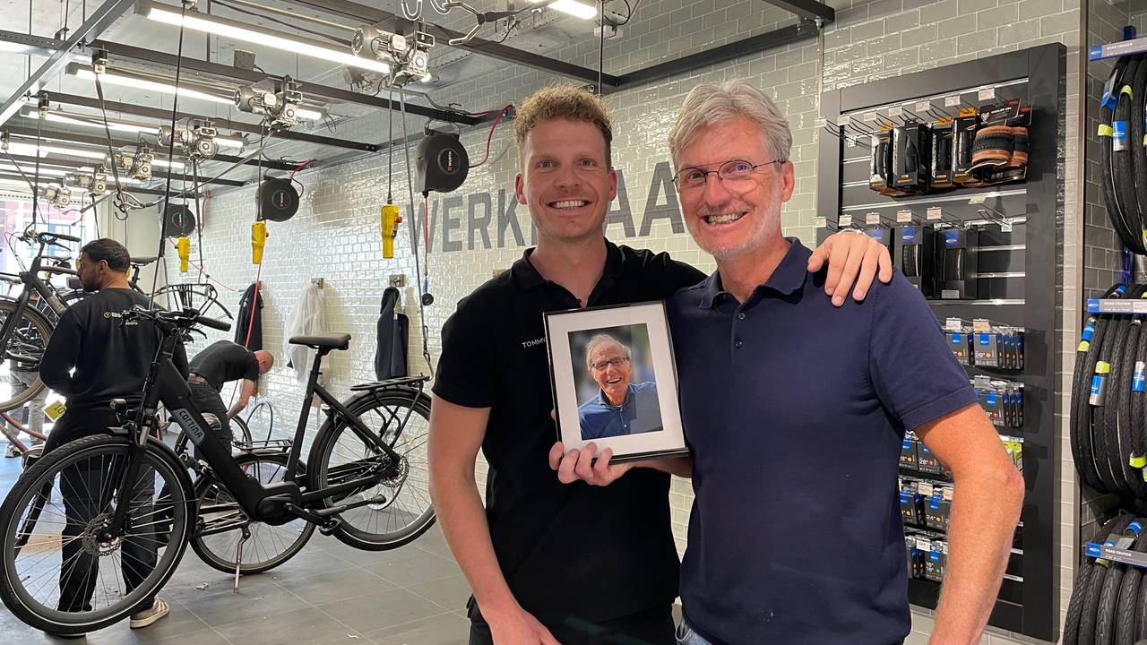 Tommy en Rick in de fietsenwinkel met een foto van opa/ vader Jan (foto: Megan Hanegraaf).