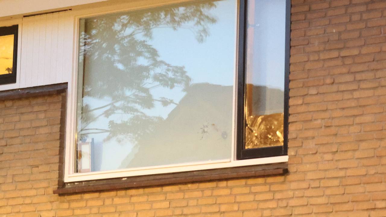 In zowel een raam boven als beneden is een kogelinslag te zien.