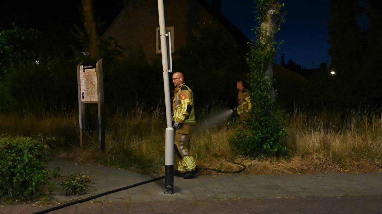 De brandweer bluste nog even na nadat een agent het vuur aan de Rochussenstraat in Breda al had gedoofd (foto: Perry Roovers/SQ Vision).