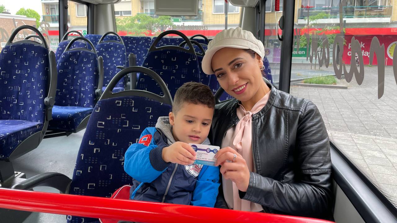 Safa en zoontje Thijmen met hun gratis buspas (foto: Tom van den Oetelaar).