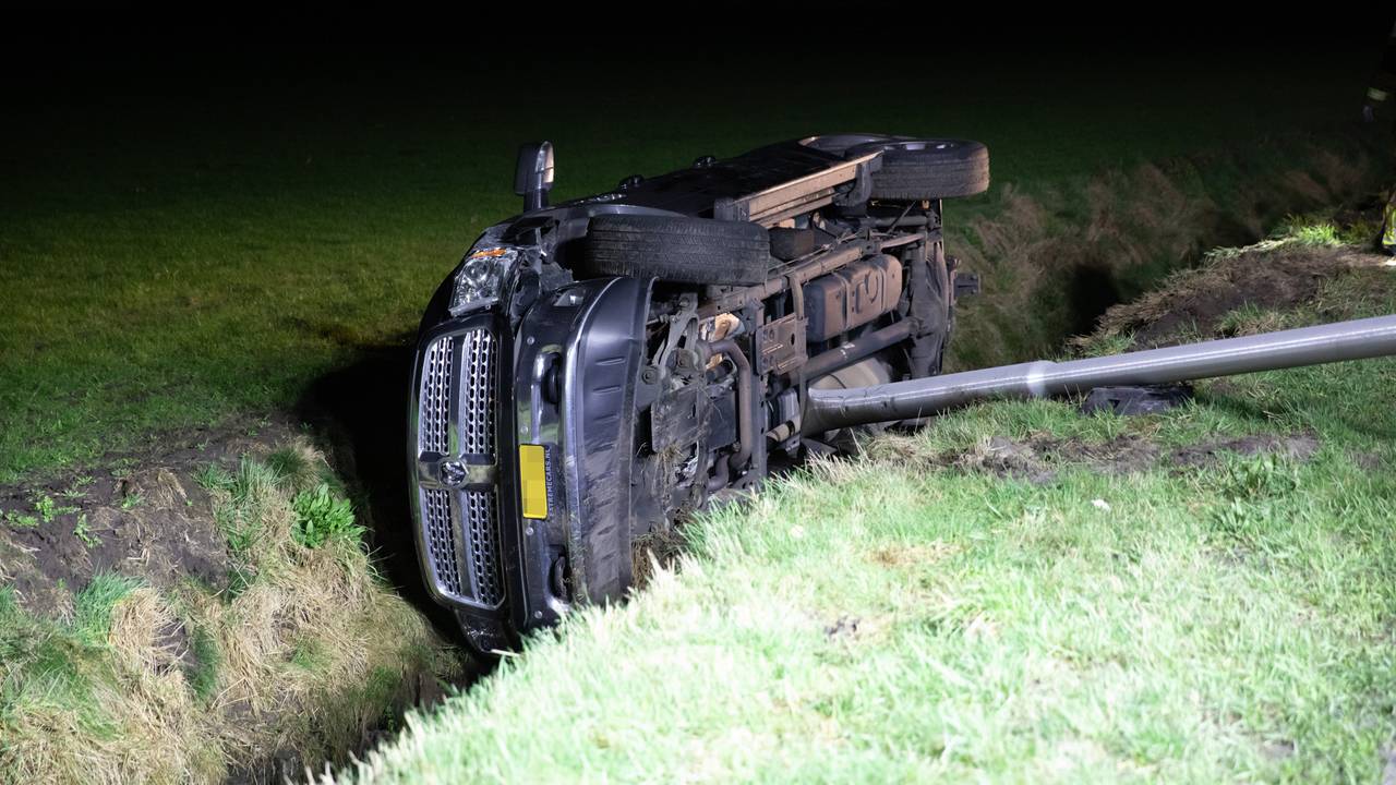 De automobilist reed een lantaarnpaal uit de grond voordat hij in de sloot in Rucphen terechtkwam (foto: Christian Traets/SQ Vision). 