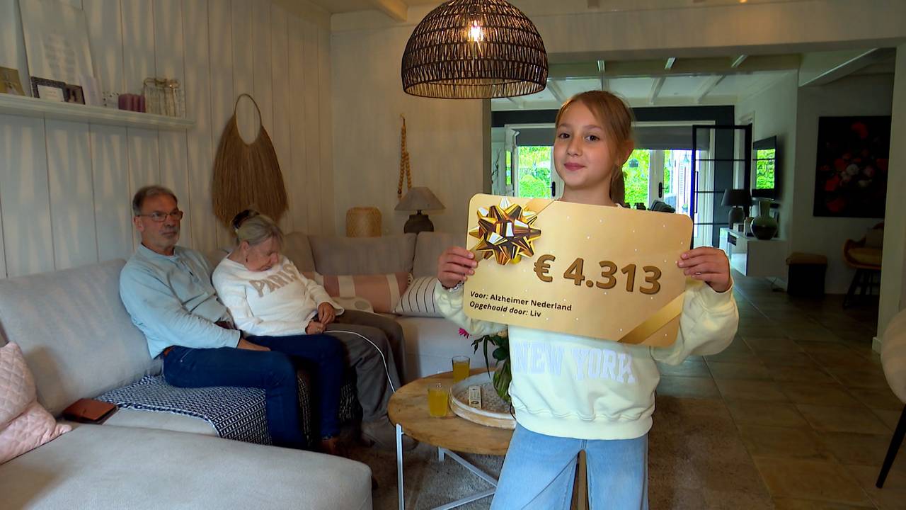Liv laat trots haar cheque van ruim 4300 euro zien, op de achtergrond haar opa en oma (foto: Omroep Brabant).