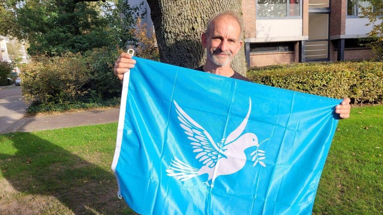 Johan Vlemmix met zijn zelf ontworpen vredesvlag (foto: Johan Vlemmix).