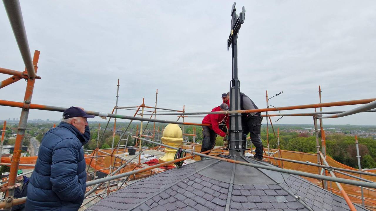 Toon Dolphijn kijkt van grote hoogte toe bij het plaatsen van de koepel en het kruis (Foto: Noël van Hooft)