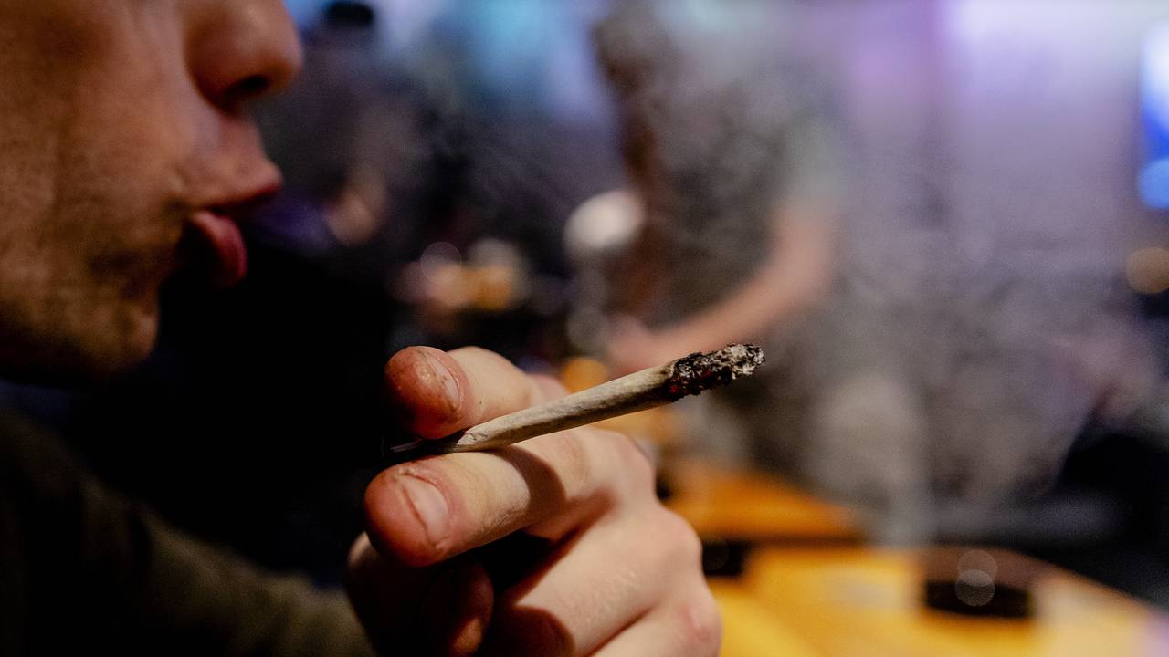 Een bezoeker van coffeeshop steekt een joint op (foto: ANP / Robin van Lonkhuijsen).