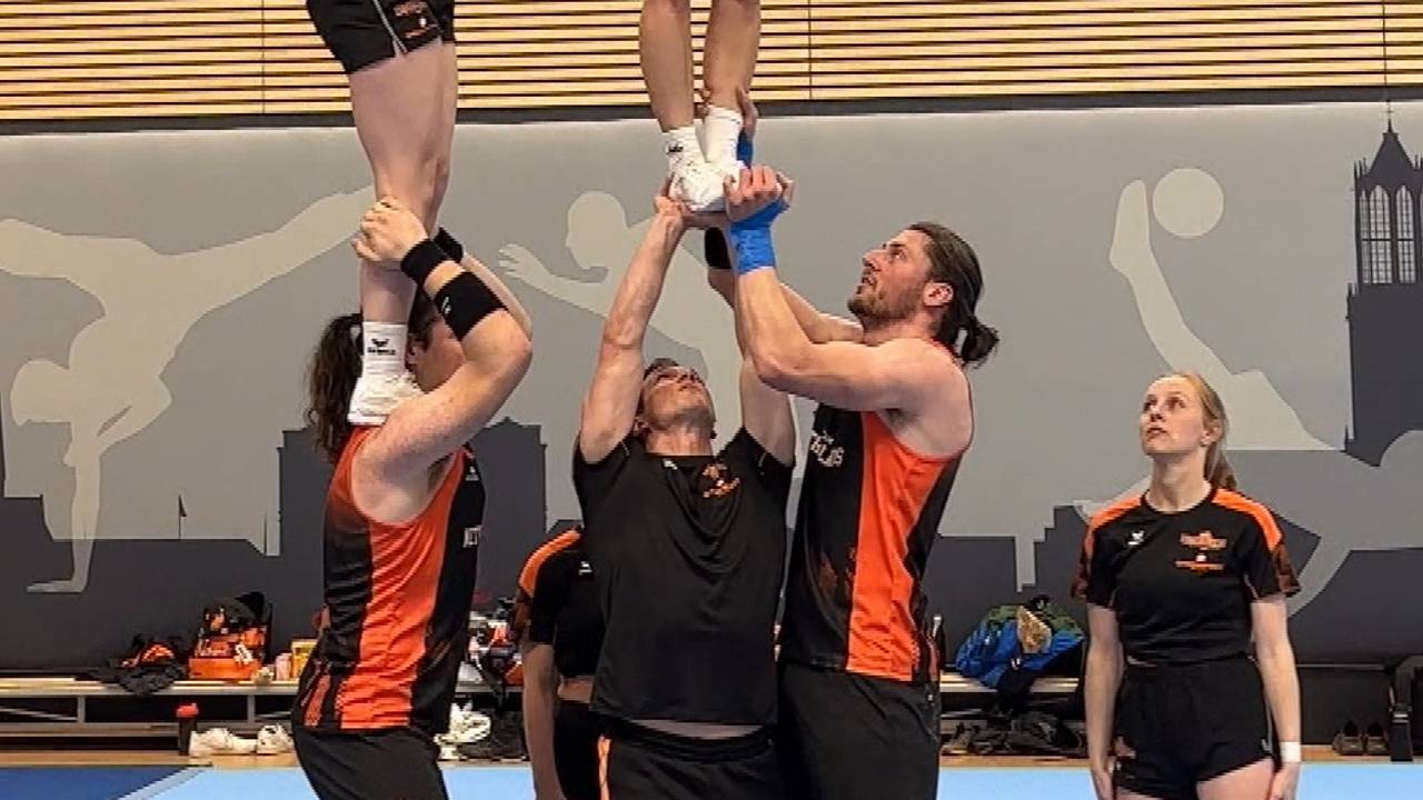 Jens en Karsten (rechts) tillen een teamgenote op.