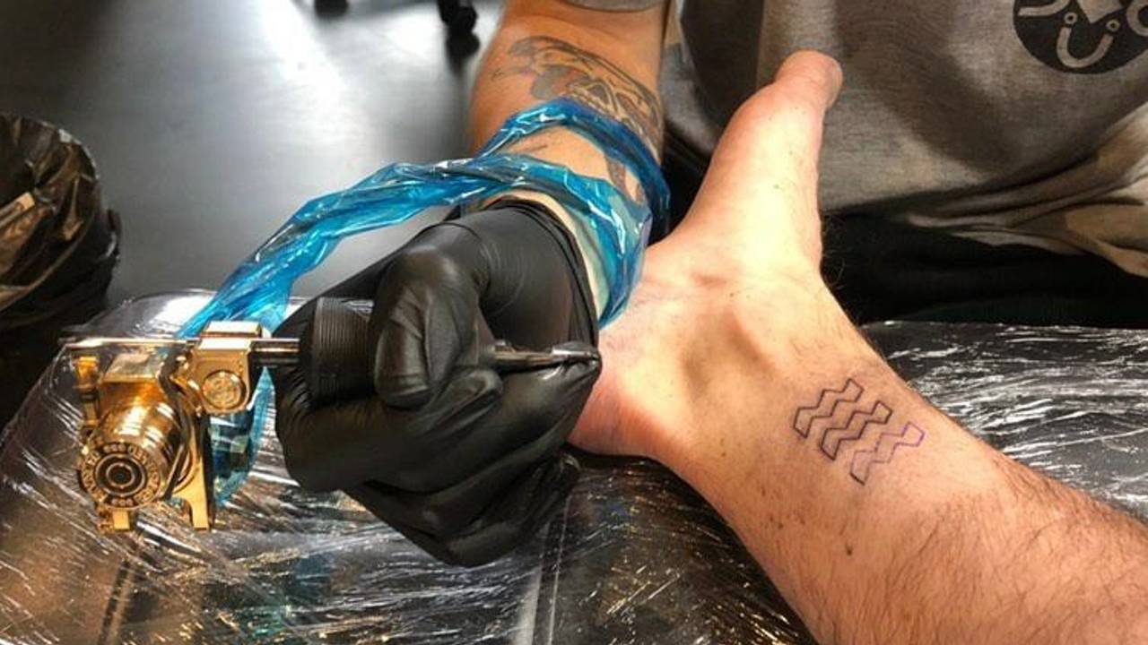 Max krijgt het logo van Eindhoven boven zijn enkel. (Foto: Max den Holder)