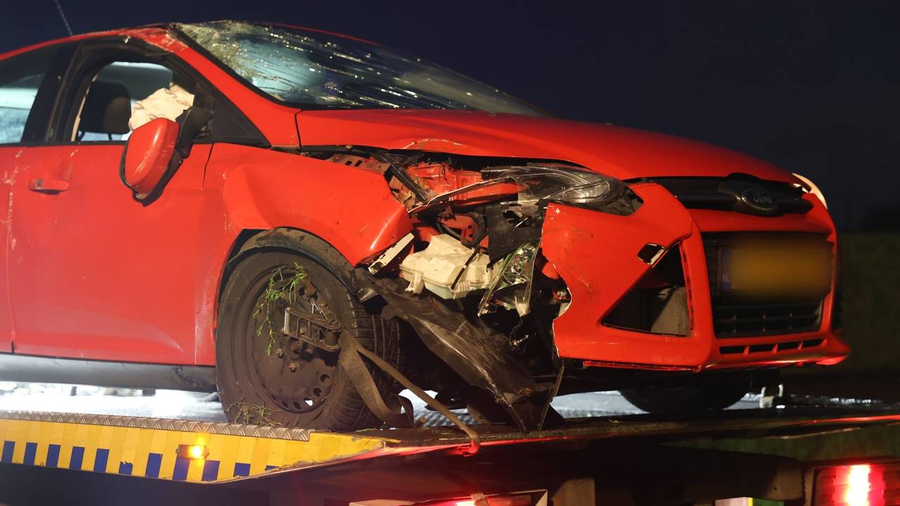 Een berger nam de zwaar beschadigde auto na de botsing in Liempde  mee (foto: Sander van Gils/SQ Vision).