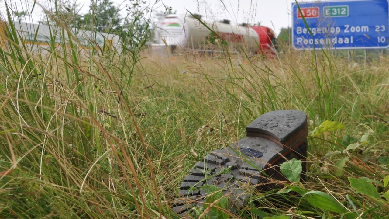 Een verdwaalde schoen in de berm langs de snelweg A58.