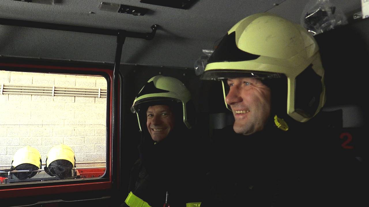 Rini (links) met collega Harry in de brandweerwagen.