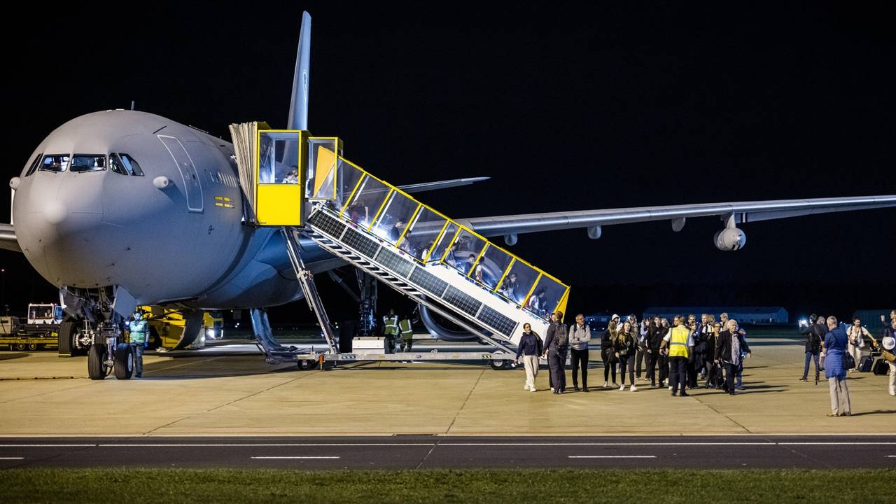 Reizigers verlaten een militair vliegtuig op vliegbasis Eindhoven (foto: ANP).