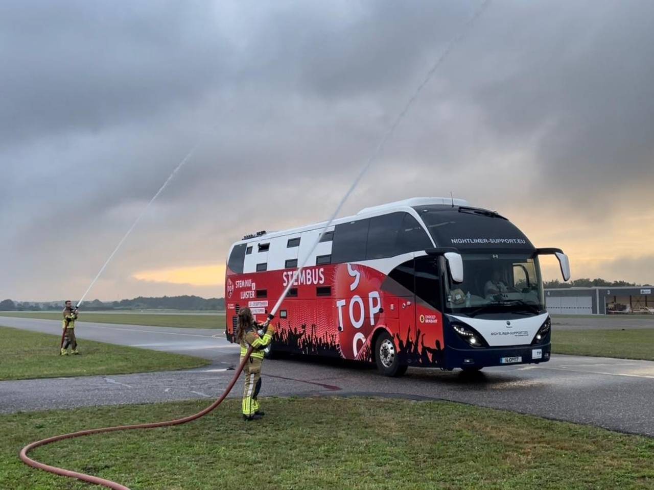 De bus onder het watersalut op Breda International Airport.