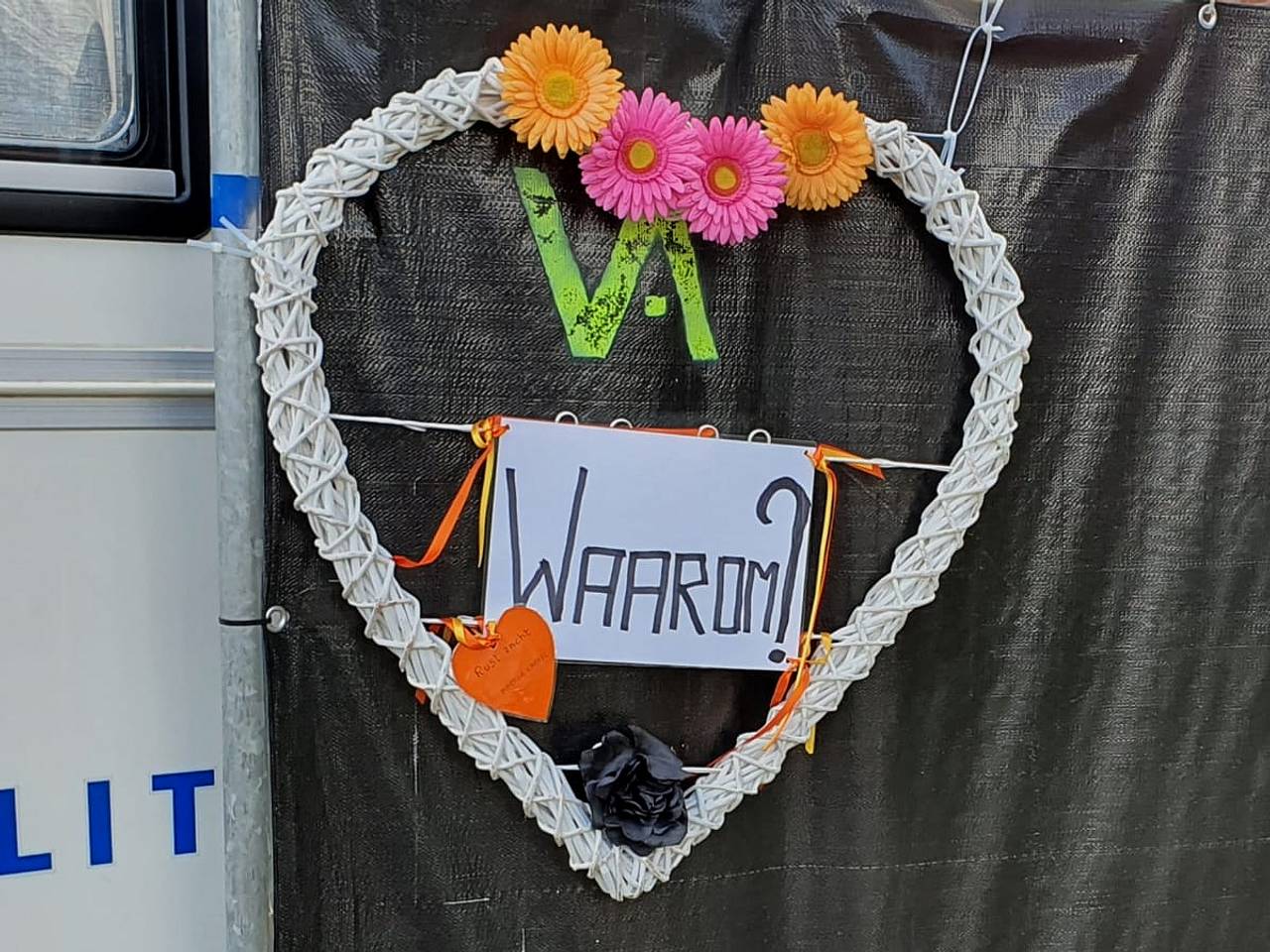 Bloemstukje opgehangen bij de zwarte schermen voor de woning in Etten-Leur.