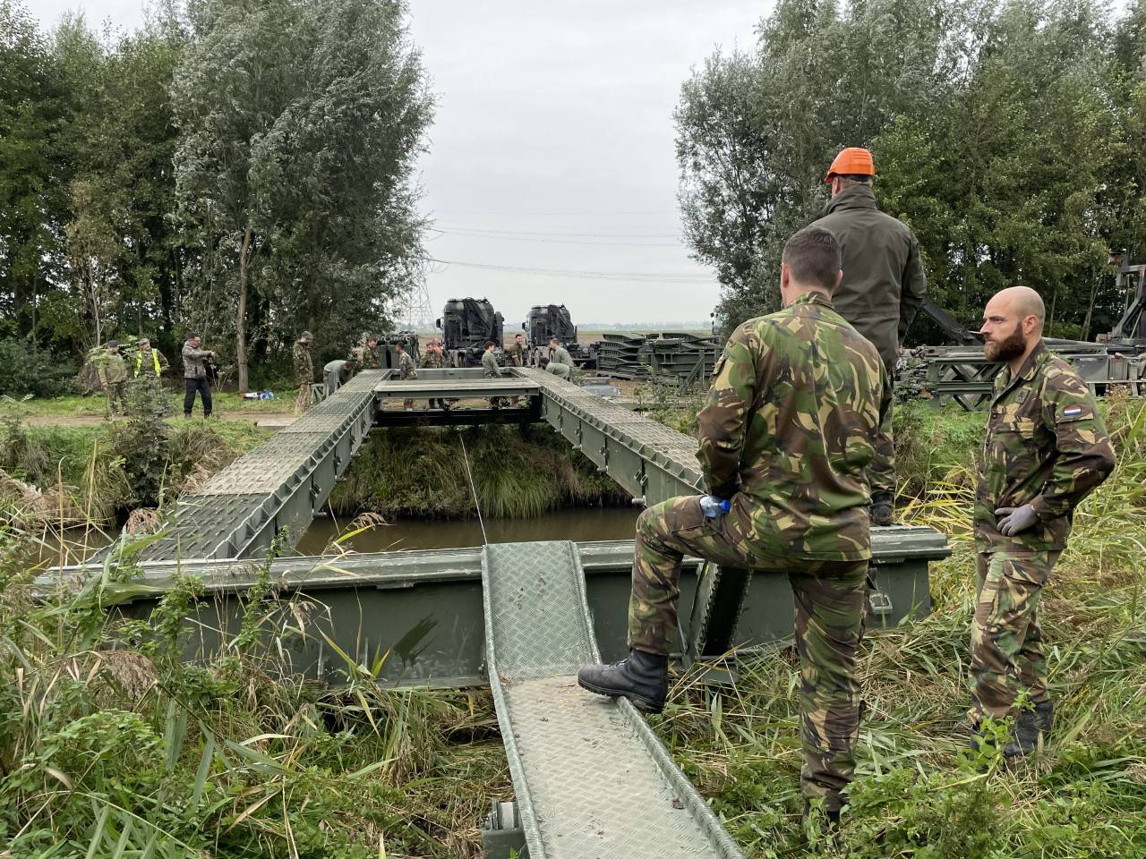Leden van defensie bouwen een brug.