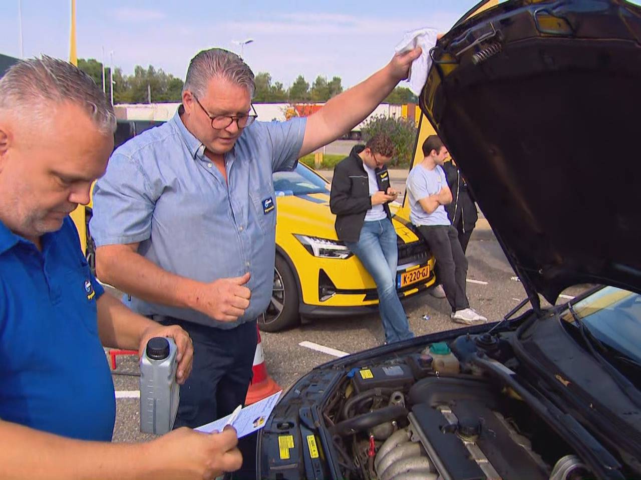 René (rechts) en een collega controleren onder de motorkap