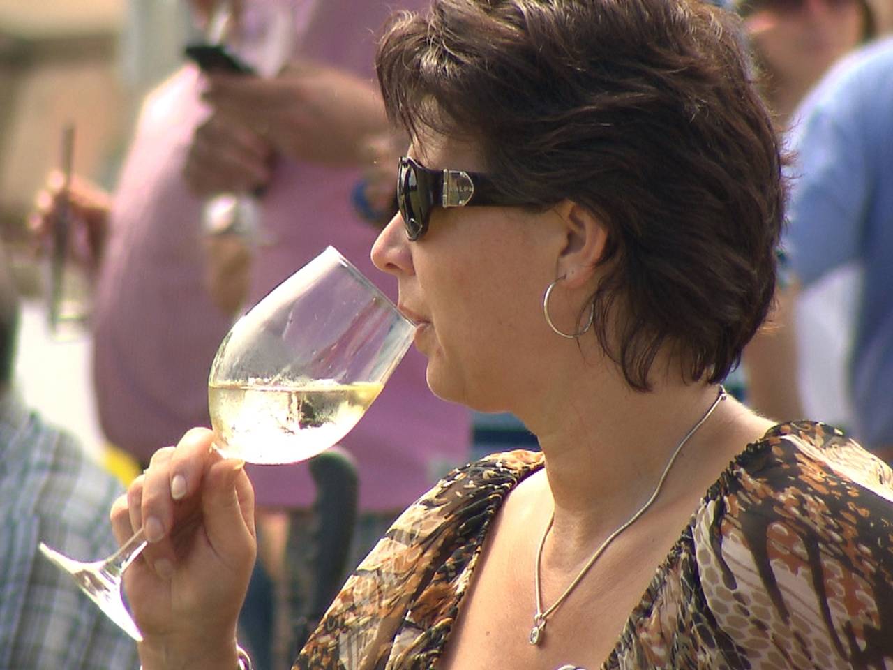 Met 'n glas witte wijn in de hand genieten van de polosport tijdens Pinkster Polo in Waalre