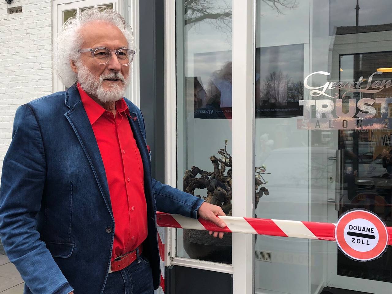 Kapper Maarten Ploegmakers bij de ludieke grensovergang voor zijn salon in Schaijk
