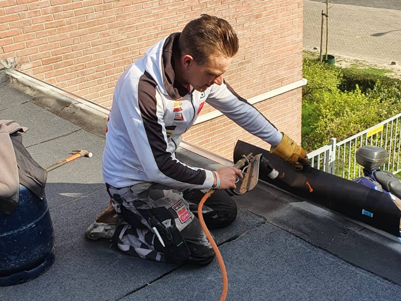 Etienne Bax niet aan het crossen, maar aan het werk op het dak.