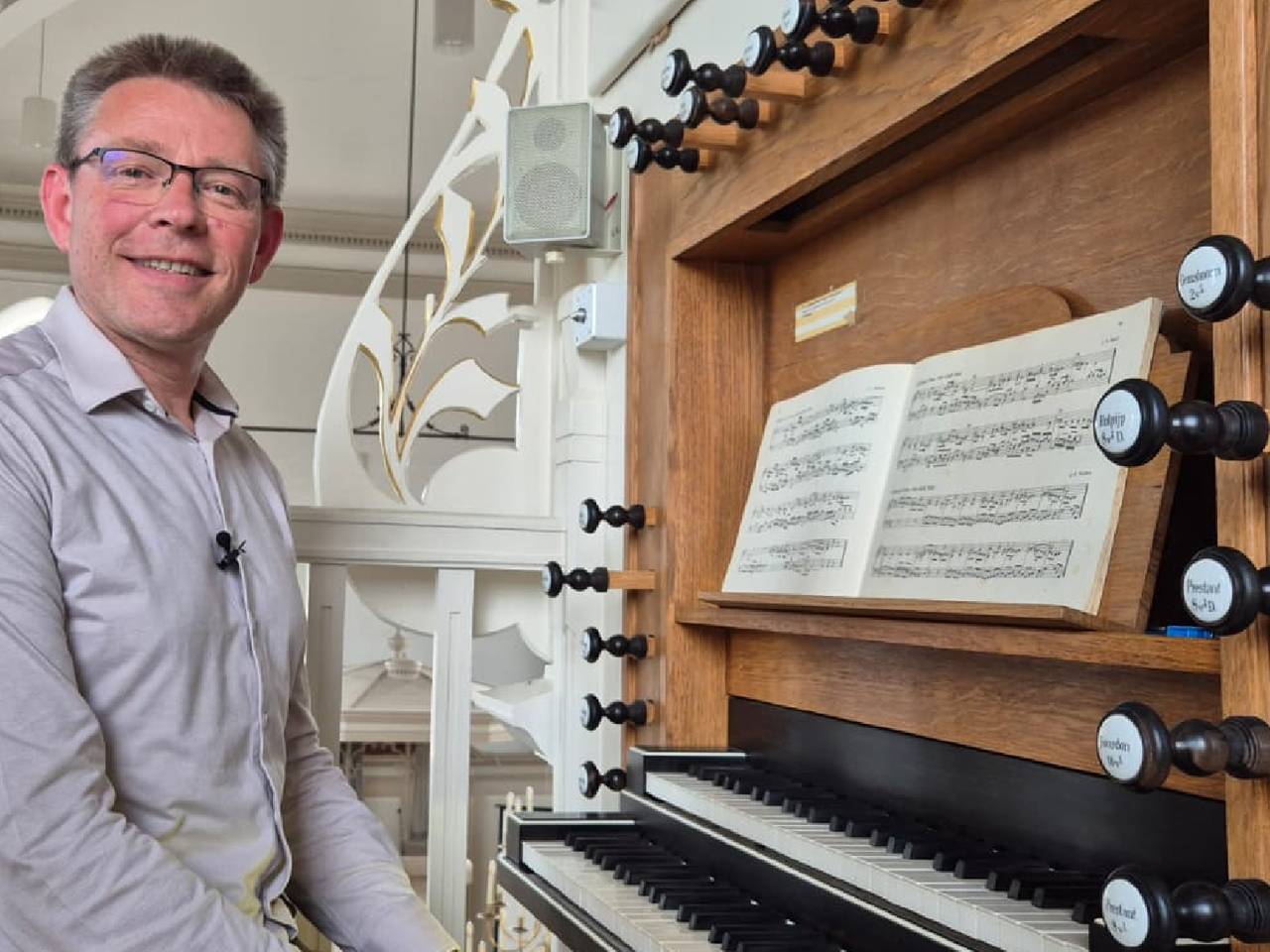 Organist Aad de Ligt achter het defecte orgel in de Protestantse Kerk in Hooge Zwaluwe (foto: Niek de Bruijn)