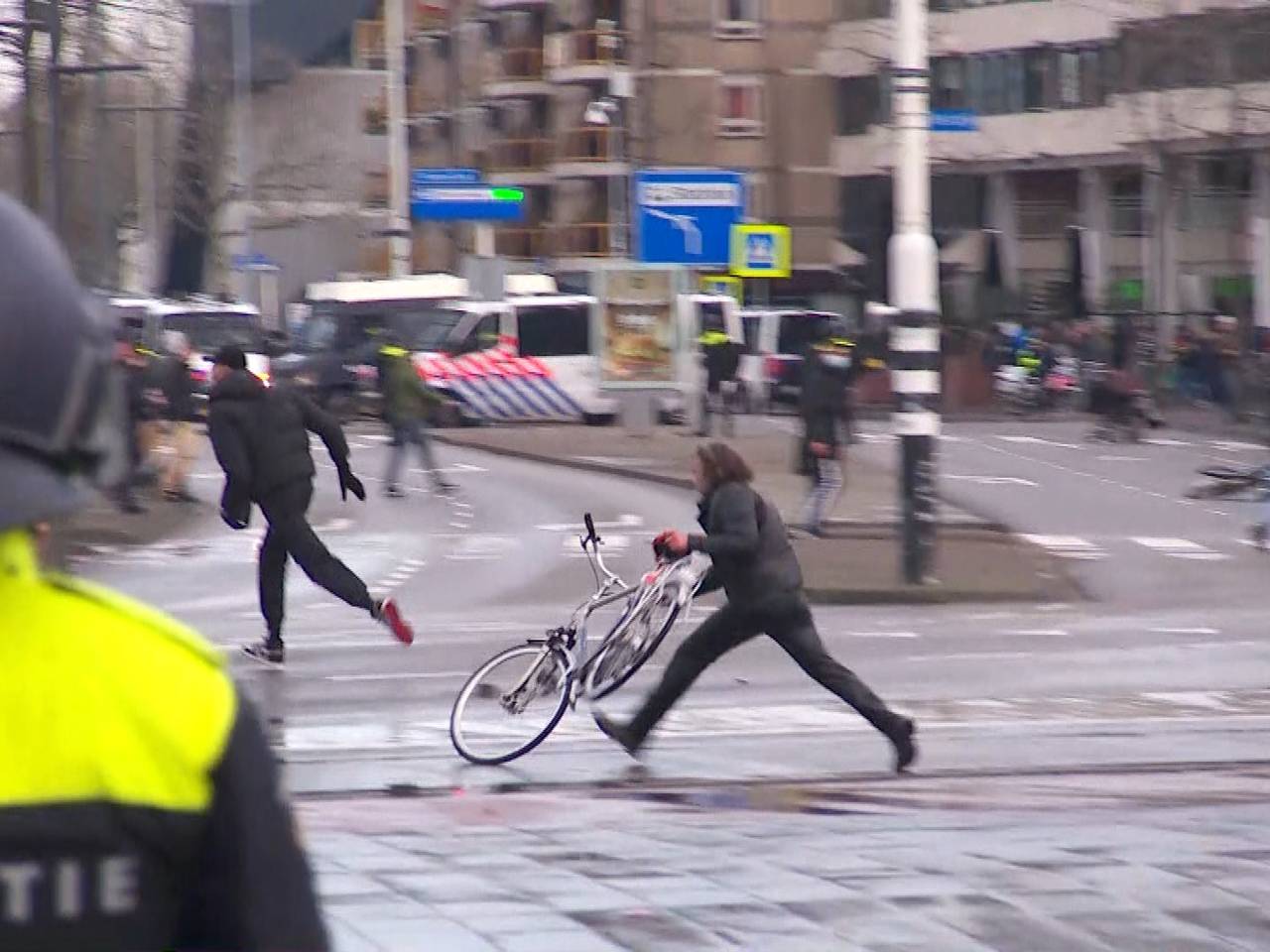 Man gooit fiets onder waterkanon.