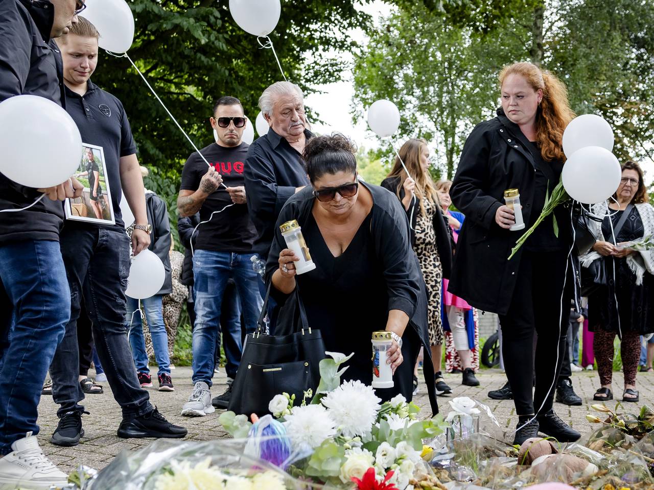 deelnemers aan de stille tocht lopen met witte ballonnen en leggen bloemen neer op de plek waar Joeweela werd gedood (ANP).