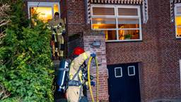 Brand onder overkapping huis, bewoners uit huis gehaald vanwege rook