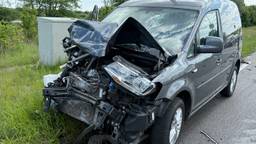 Bestuurder gewond na botsing, weg bezaaid met brokstukken van auto