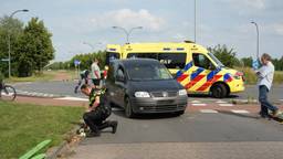 Auto schept fietser op rotonde