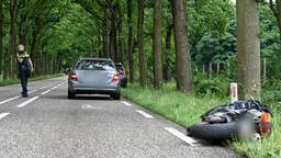 Motorrijder haalt rij auto's in en botst achterop