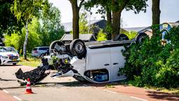 Busje belandt ondersteboven na ongeluk en eindigt tegen boom