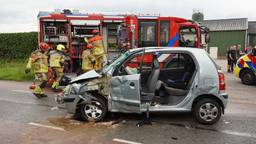 Vrouw bekneld in auto na botsing met vrachtwagen