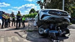 Auto belandt bovenop stoeltjes en scootmobiel, één gewonde