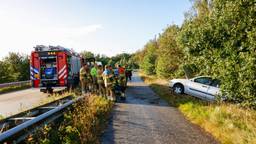Vrouw raakt met auto van de weg en knalt tegen boom