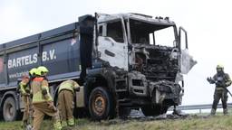 Beelden van de brandweer die bezig is met de volledig uitgebrande vrachtwagen