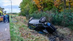Auto botst op lantaarnpaal en belandt op zijn kop in de sloot