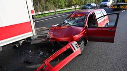 Auto rijdt achterop vrachtwagen, laadklep ligt op de snelweg