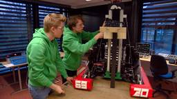 Studenten monteren de laatste onderdelen op hun zelfgebouwde robot