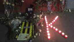 Bij het huis van de doodgeschoten Kaan S. staan een foto, rozen en een ‘K’ van kaarsen (foto: Raymond Merkx)