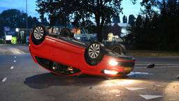 Auto crasht en eindigt op dak in Breda