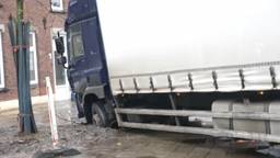 Op de Boterstraat in Oss is een vrachtwagen met een voorwiel in de modder beland