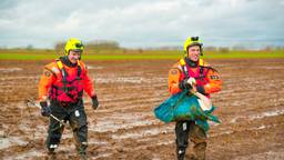 Twee brandweermannen met een van de zwanen