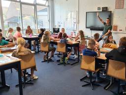 Vrolijk beginnen kinderen aan nieuw schooljaar in gebouw dat minder fris is