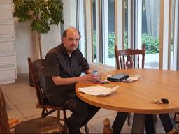 Gert Regterschot aan de tafel in de studentenflat waar hij iedere dag zit (Foto: Han Konings/Cursor).