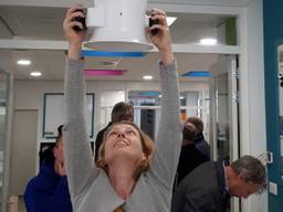 Froukje meet de hoeveelheid lucht door een ventilatierooster in een school. (Foto: Froukje van Dijken)