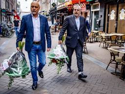 Advocaten Onno de Jong (l) en  Peter Schouten (r) leggen bloemen neer op de plek waar Peter R. de Vries is neergeschoten (foto: ANP).