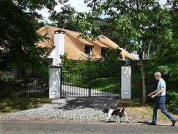 Een man laat zijn hond uit in een villawijk in Leende (foto: Peter Hilz / ANP).