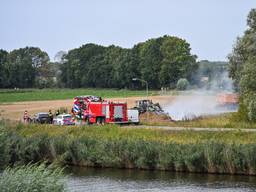 De brandweer bezig met het blussen van het hooi (foto: Tom van der Put/Persbureau Heitink).