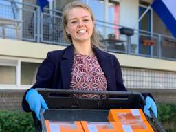 Studente Lisanne van Ree bezorgt oranje tompoucen bij ouderen in Tilburg. (foto: Eva de Schipper)