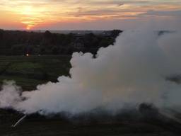 Stinkende rookwolken trekken over stad nadat stapel gemaaid gras vlam vat