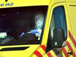 Een volledig tegen het coronavirus ingepakt ambulancechauffeur (archieffoto).